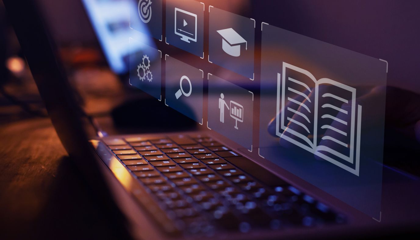 Moduły e-learningowe i ikony edukacyjne wyświetlane nad laptopem, symbolizujące microlearning oraz naukę online.